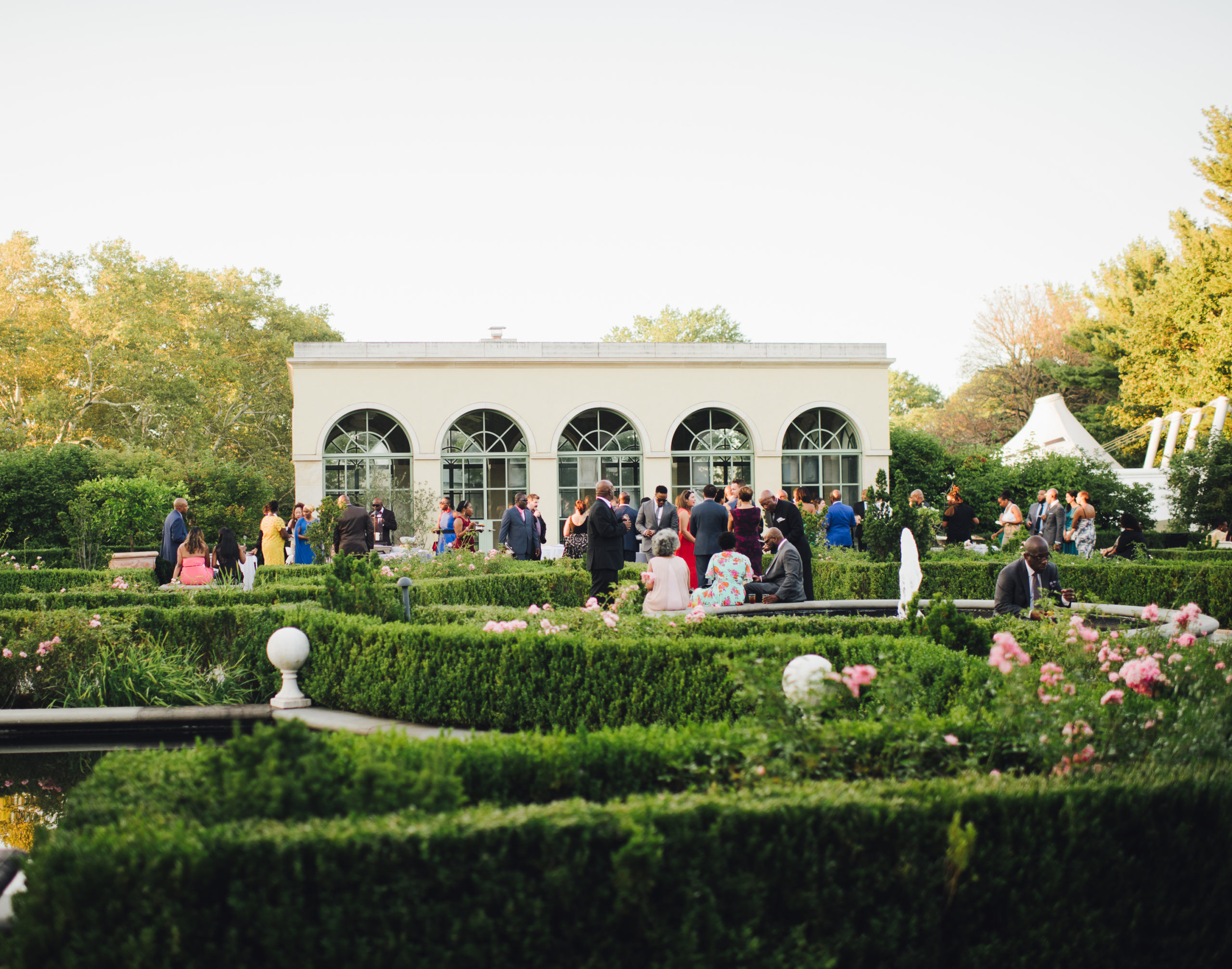 Outdoor New York City wedding venue where the guests mingle among perfectly trimmed bushes at an intimate venue